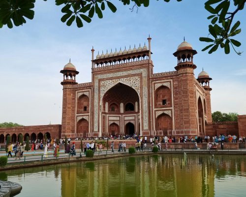 The iconic entrance gate of Red Fort in Agra, India, on a sunny day with tourists.