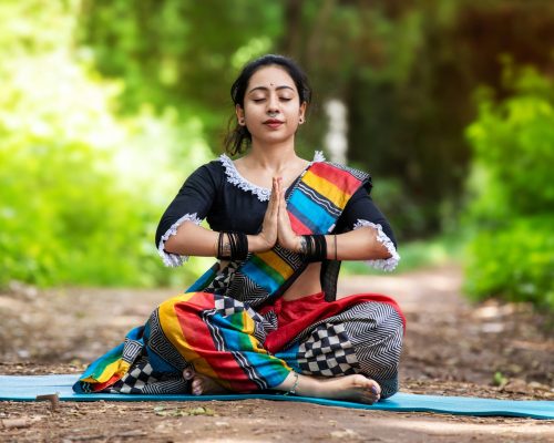 Woman practicing yoga outdoors in colorful attire, embracing mindfulness and inner peace.