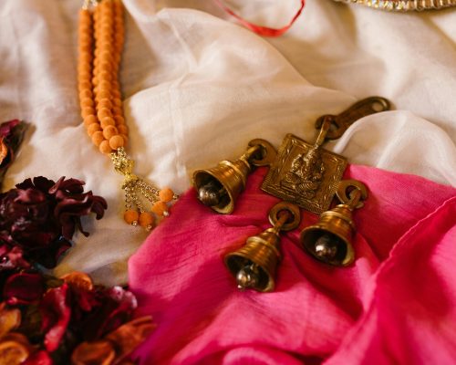 Colorful arrangement of Ganesha bells, beads, and petals symbolizing Indian festivals and traditions.